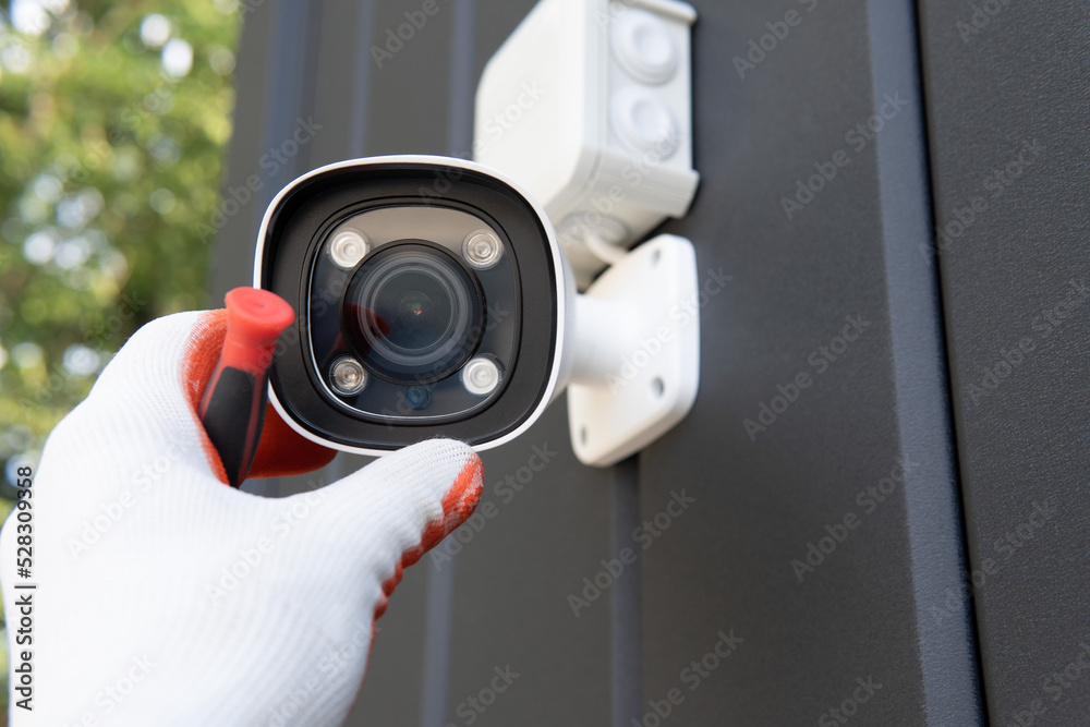Worker installing a security camera on site